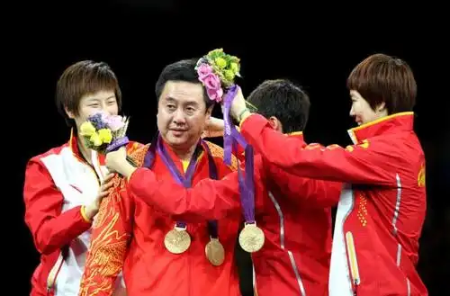 乒乓球男子团体颁奖仪式上,中国队选手在颁奖台上为男队主教练刘国梁