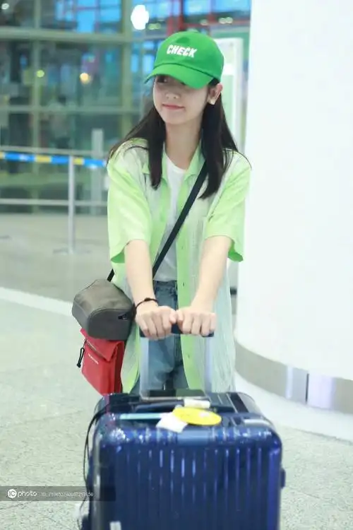 新晋玛丽苏女主邢菲头戴绿帽子独自推行李箱活力满满
