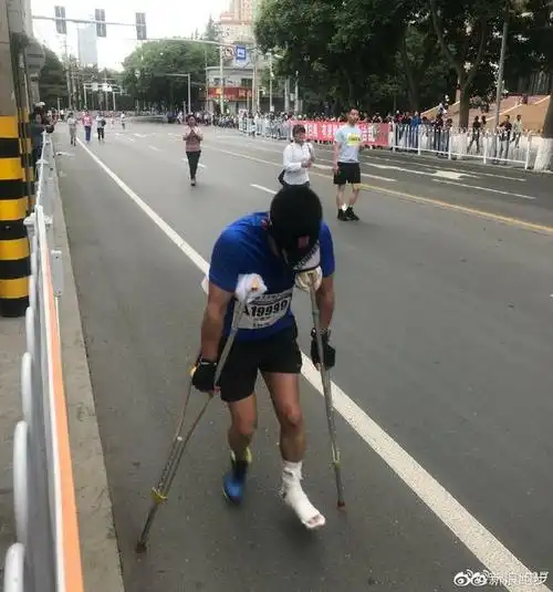 兰州马拉松选手拄双拐参赛 家门口的比赛不想放弃