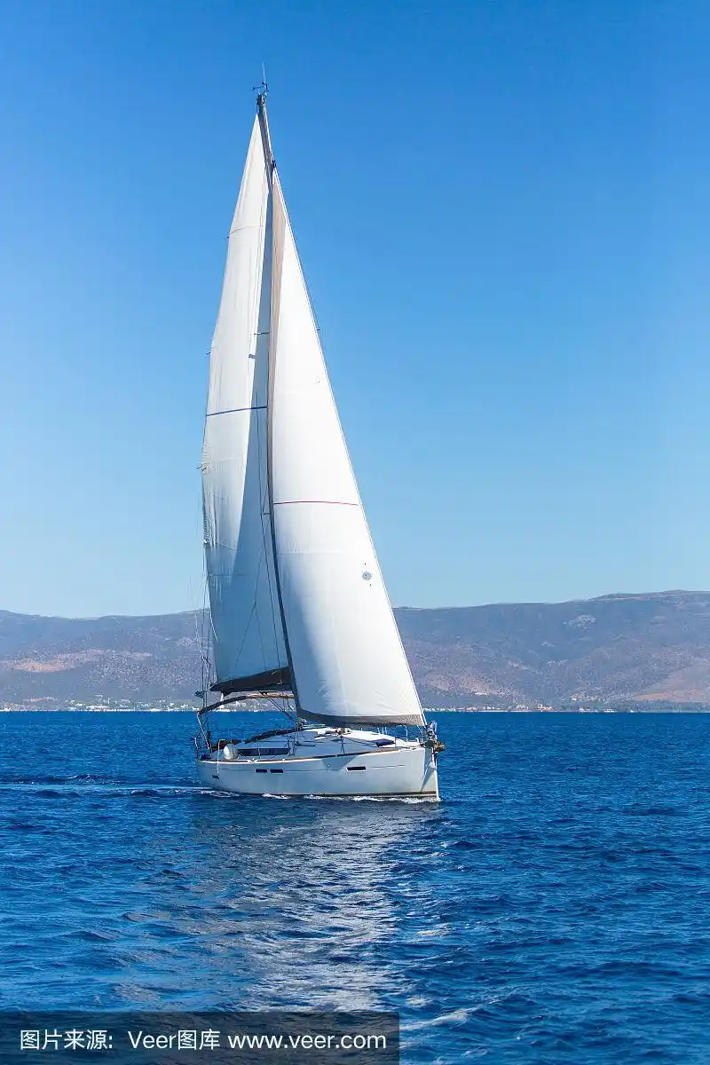 航行的船只在海上挂着白帆.