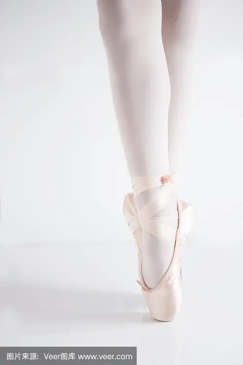 腿和脚与粉红色缎子尖头鞋由一个经典的芭蕾舞女踮脚