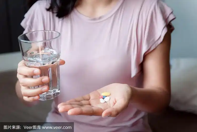 特写女人的手是拿着一杯水,而服用药丸,保健和药物的概念
