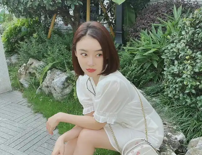 袁姗姗一袭白色连衣裙搭配粉色爱心链条包,齐肩短发干净利落