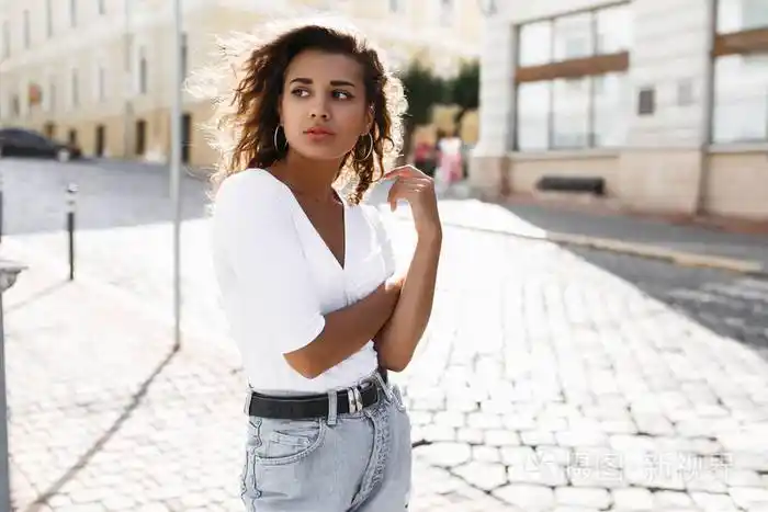 年轻富于表现力的黑发卷发女人古铜色皮肤自然沿街走来