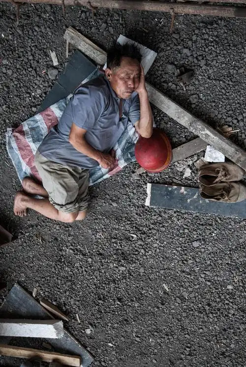 两名农民工躺在工地里休息,为了能舒服