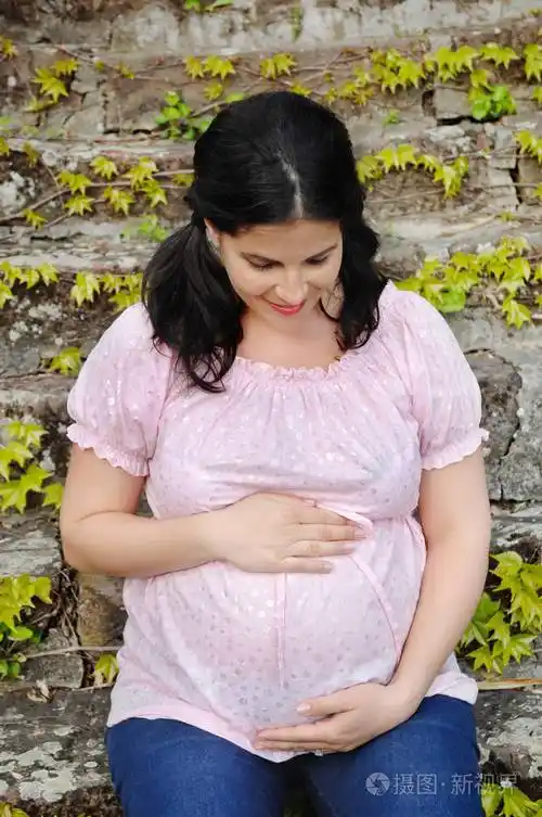怀孕的女人抱着她的肚子照片-正版商用图片0prw9e-摄图新视界