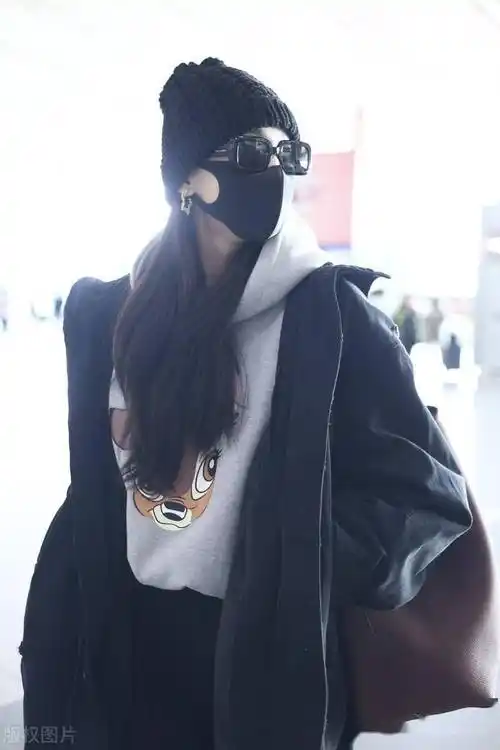 街拍:古力娜扎黑色派克服 印花连帽卫衣 针织帽 微喇裤低调温暖_北京