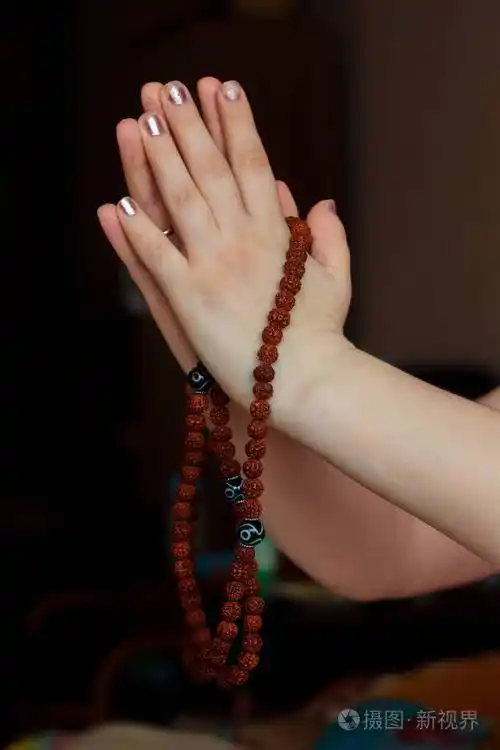 妇女手拿着rudraksha念珠与合十礼手印