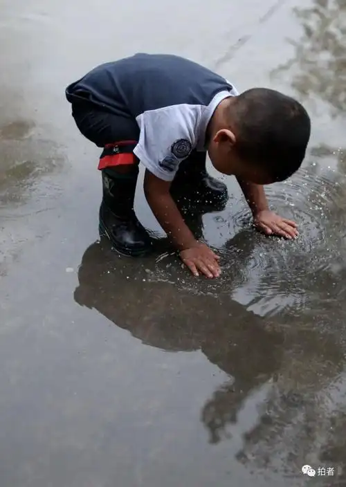 2009年9月4日,青云店,一场大雨过后,一个小朋友穿着雨鞋,双手触摸地