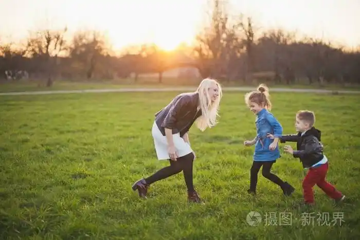 母亲带着两个孩子在草坪上