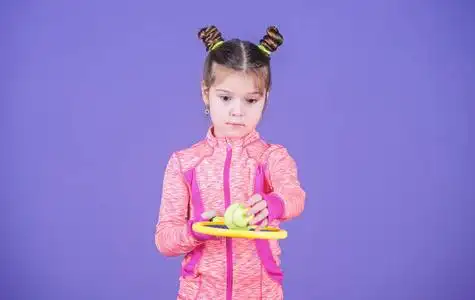 教我怎么打网球.女孩可爱的孩子双髻发型网球运动员.
