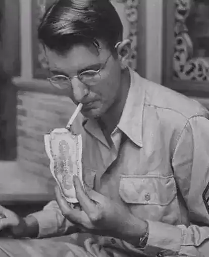 一位美国大兵在用钞票点烟,这在当时并不奢侈