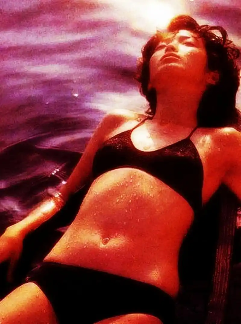 80年代著名女歌手山口百惠穿着泳衣在沙滩上享受阳光和海水.