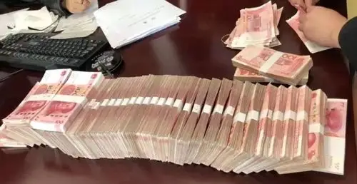 大队办公室人头攒动办公桌上堆满了一捆捆崭新的人民币这是什么情况?