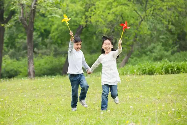 快乐的孩子们在草地上玩纸风车