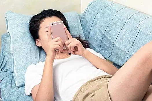 女生躺着玩手机