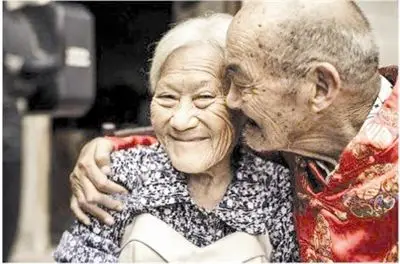 在老爷爷的怀抱中,老奶奶笑得很羞涩.
