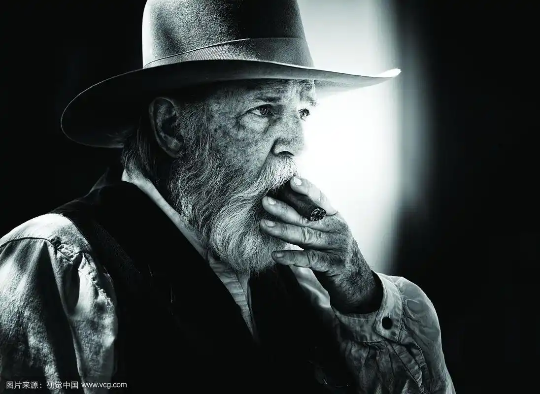 黑白肖像的老人在牛仔帽吸烟的雪茄
