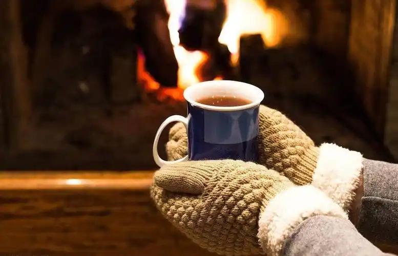 手捧茶叶手捧一杯热气腾腾的热茶在乡间木桌上照片冬天的情绪女手捧杯