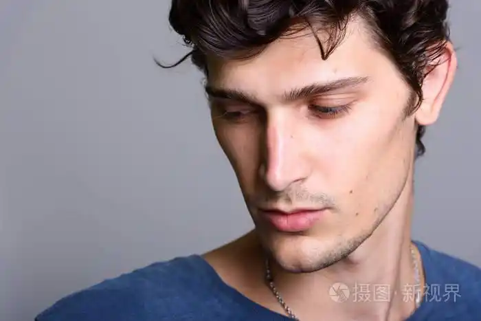 年轻英俊的男人,同时低头思考的特写