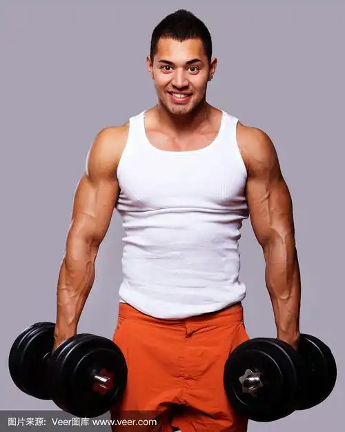健美的肌肉男用哑铃锻炼