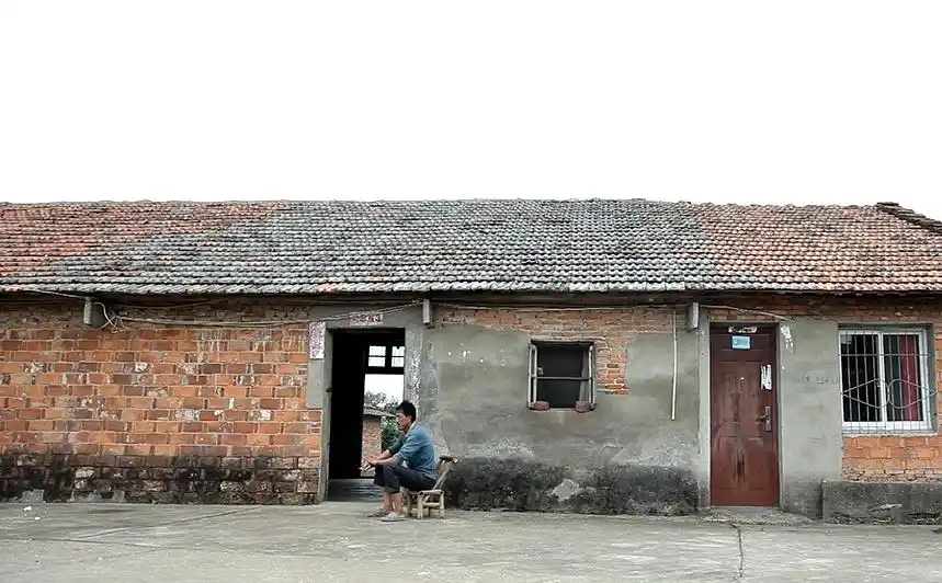 与前后大气华丽的楼房相比,李学华家的那栋砖瓦小平房显得十分破旧