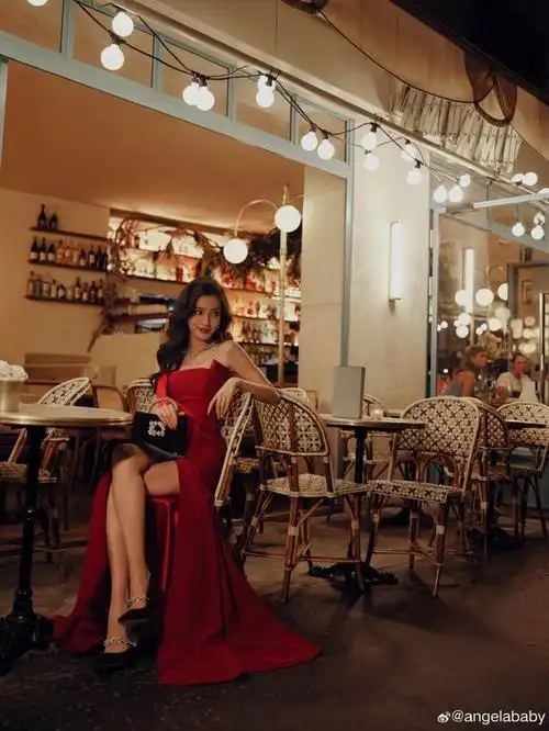 angelababy身穿一套抹胸开叉的红色长裙,优雅地摇曳在夜晚的黑暗中.