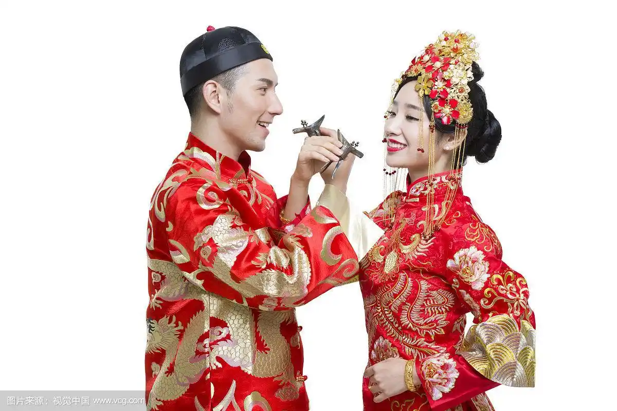 穿中式古装结婚礼服的新娘和新郎喝交杯酒