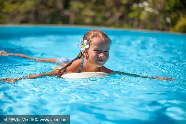 可爱快乐的小女孩在游泳池里游泳