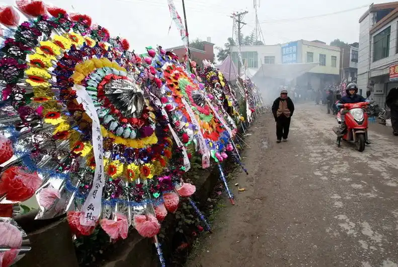 葬礼现场,道路两侧沿街摆满花圈,绵延约四五百米.