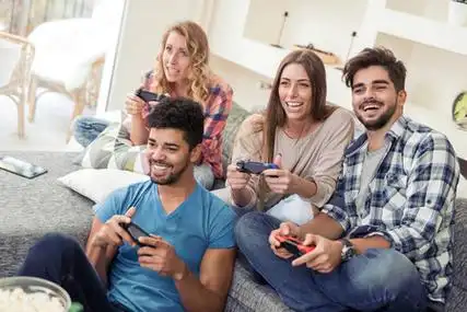 在数字平板电脑上玩游戏年轻女子一起玩游戏与外行娃娃在桌上与咖啡杯