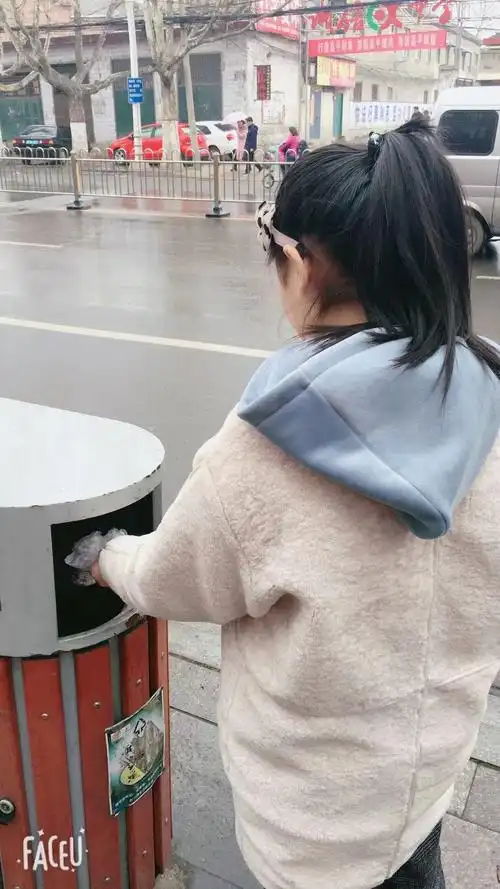 之后,走出新华书店,又看到地上有垃圾,便将它们捡起来扔入垃圾桶.