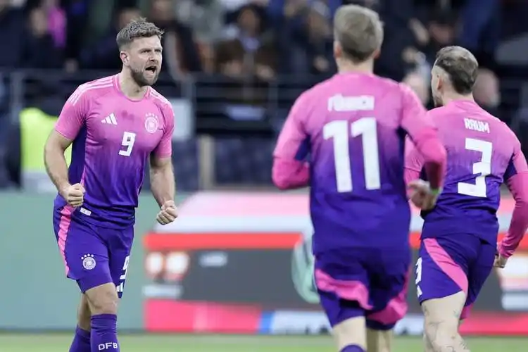 3月26日,德国队球员菲尔克鲁格(左)攻入球队第二球后与队友庆祝.