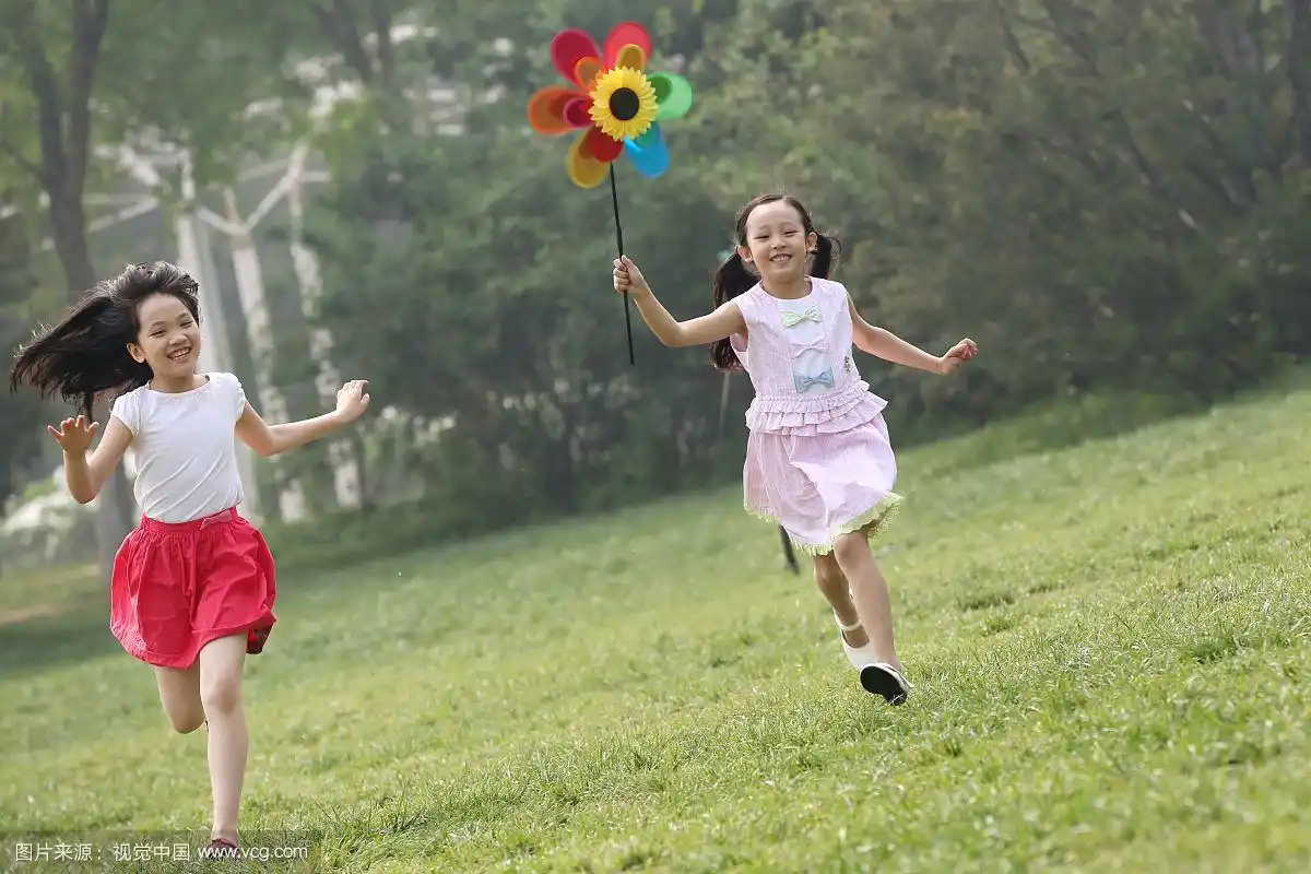 两个小女孩在草地上奔跑