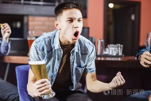 在酒吧里喝啤酒的情绪年轻男子