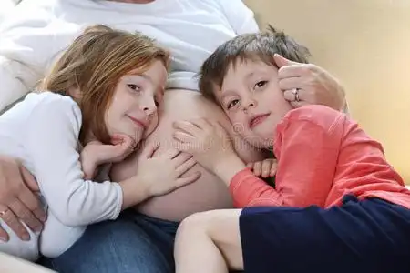 手放在肚子上的小男孩和小女孩照片