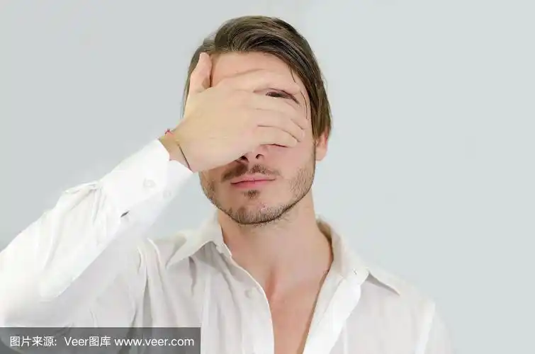 英俊的年轻人用手遮住眼睛