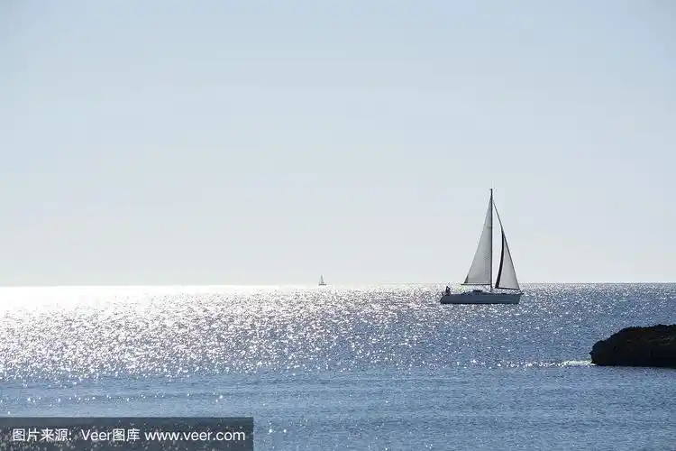 背光帆船在明亮和阳光明媚的海上与地平线