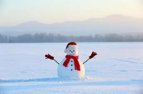 冬天的风景.圣诞节雪人戴着红帽子,围巾和手套.高山.