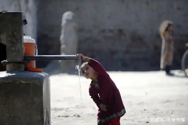 一名难民儿童在难民营内喝水