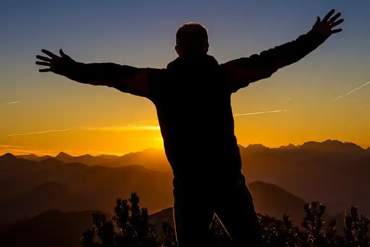 日出时山上人影的剪影图片下载