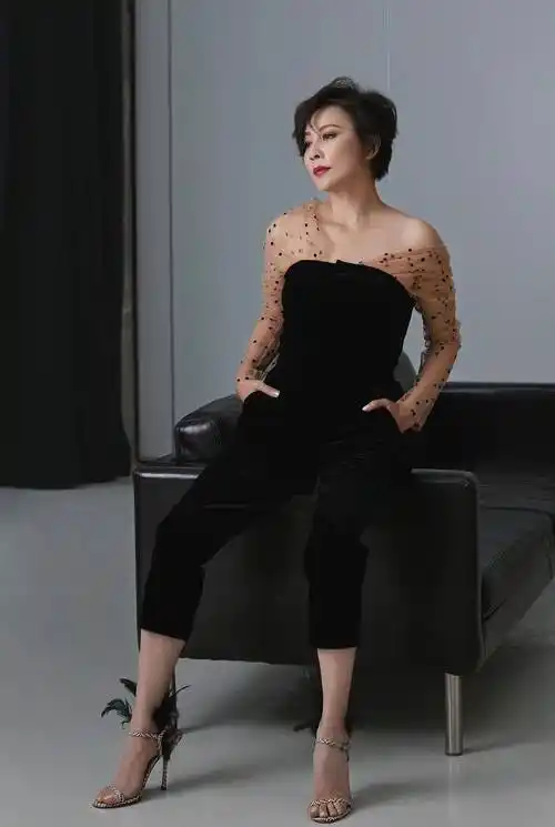 这张写真刘嘉玲身穿黑色的上衣搭配上银色的半身裙和黑色的丝袜,再次