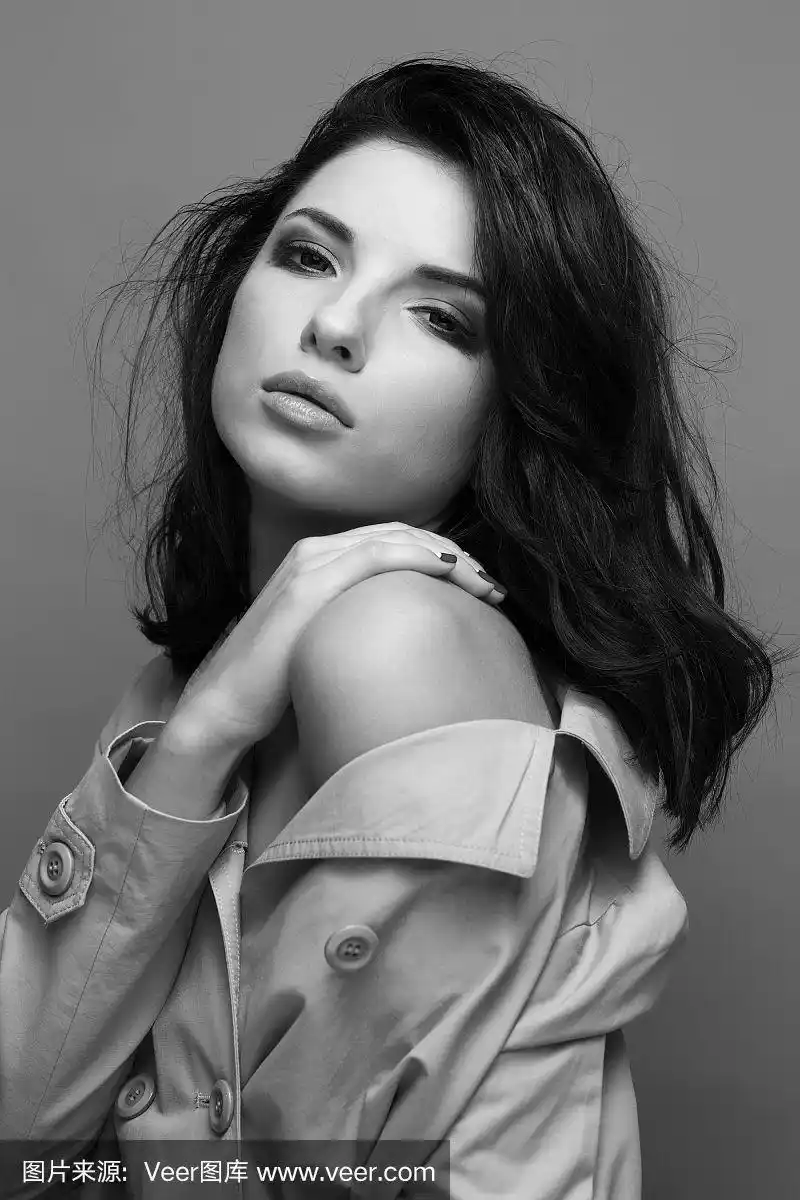 肖像迷人的女人在灰色的背景.