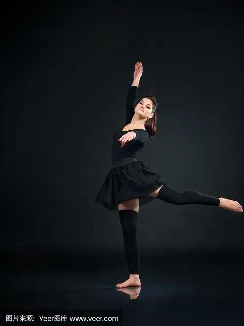 美丽的女子芭蕾舞舞者在黑色的背景上跳舞