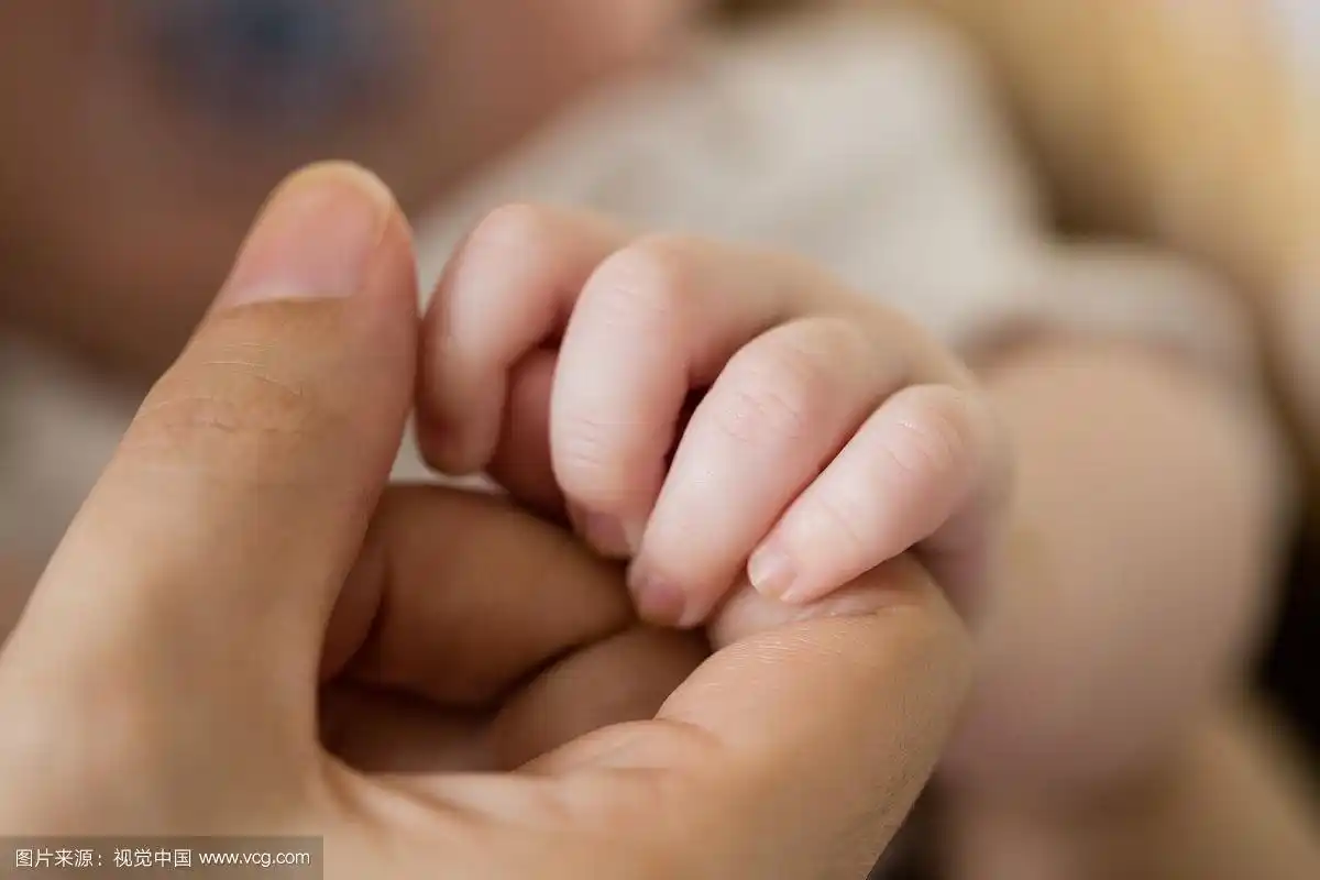 婴儿的手牵着妈妈的手的特写