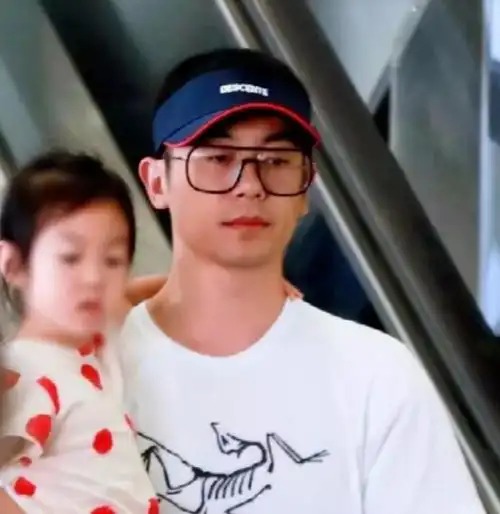 朱亚文抱女儿走机场3岁女儿五官和爸爸似复制粘贴