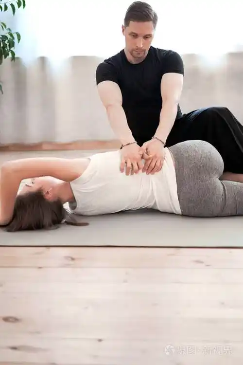 女运动员穿着运动服在地毯上伸展男教练在健身房