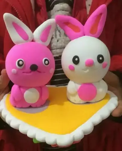 做出心盘把耳朵变成白色用同样都方法继续用粉色泥做出兔子来,粘好,一