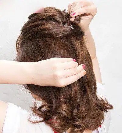 调整好两边头发的蓬松度之后,略低一些的位置,继续拉起两股头发,用小