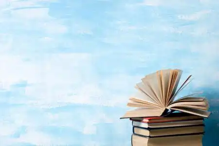 折叠的书架复古精装书,日记,木制折叠桌上扇形的书页和抽象的背景.